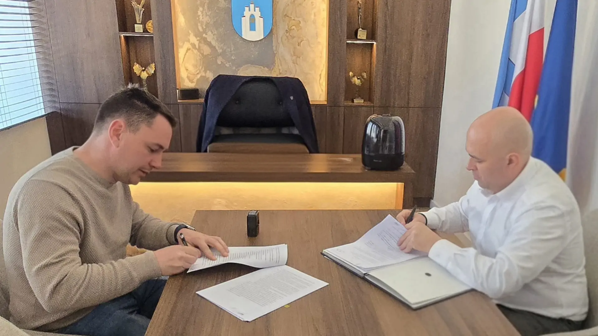 grafika z drogą i podpisywaną umową. Napis: podpisano umowę na budowę drogi